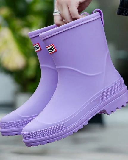 Evi paarse regenlaarzen vastgehouden aan de lus, close-up