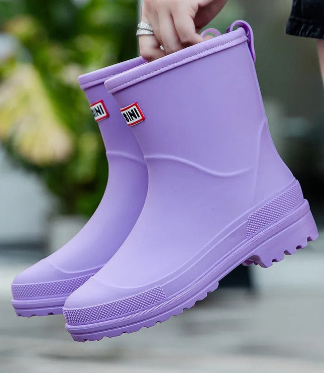 Evi paarse regenlaarzen vastgehouden aan de lus, close-up