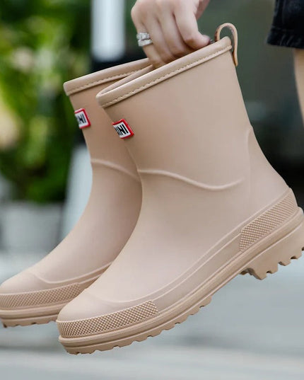 Evi beige regenlaarzen vastgehouden aan de lus, close-up
