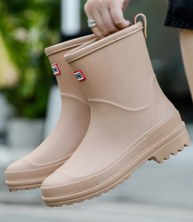 Evi beige regenlaarzen vastgehouden aan de lus, close-up